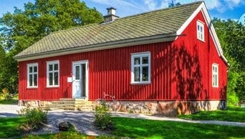 Ett stort rött hus som kan ha solceller på taket